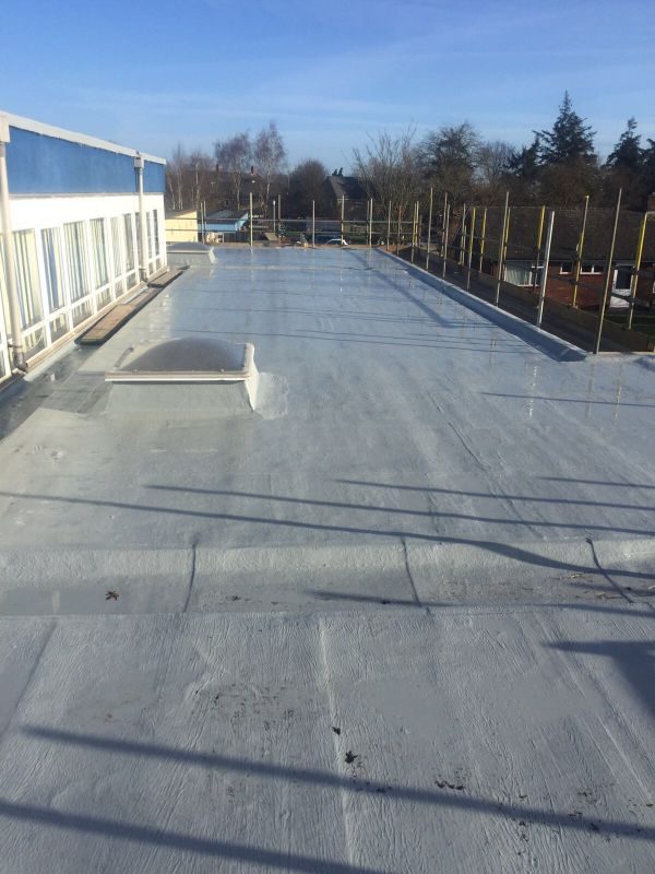 Pale grey liquid applied membrane across a large flat roof