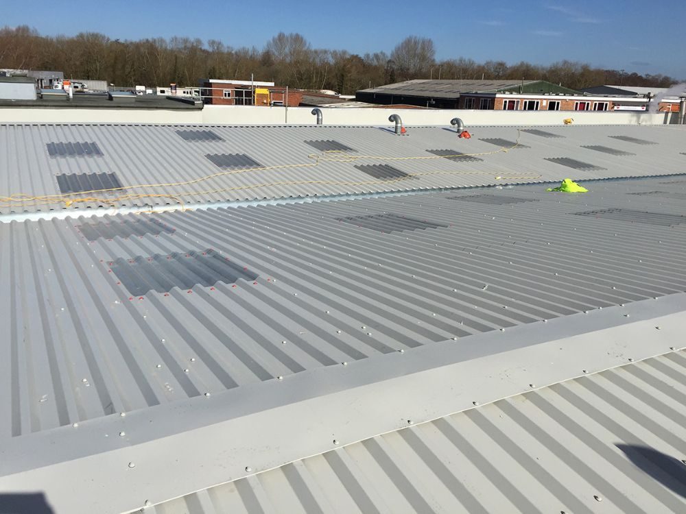 New profiled metal overcladding to an industrial roof with in-plane rooflights
